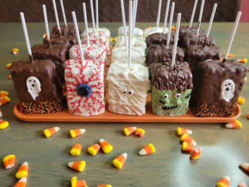 Halloween theme decorated Chocolate dipped cereal bar treats on a stick.
